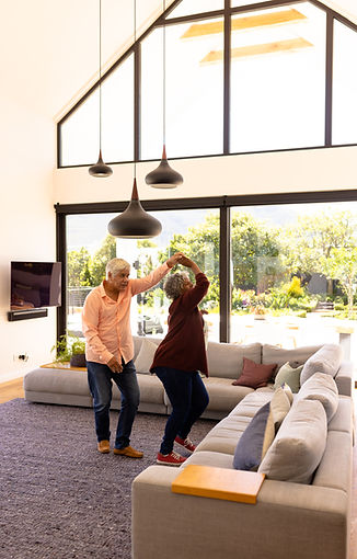 multiracial-senior-man-dancing-with-woman-by-sofa-2026-01-09-09-20-38-utc.jpg
