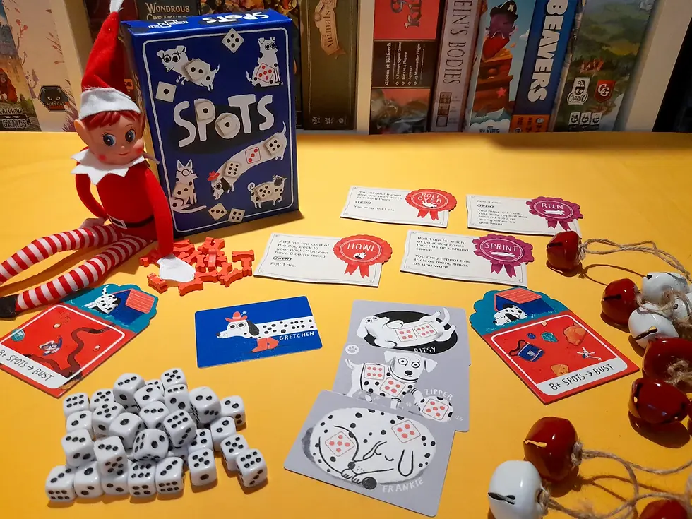 An elf toy sits beside a Spots board game box on a yellow surface. Dice, game cards, and red tokens are scattered, surrounded by board games.