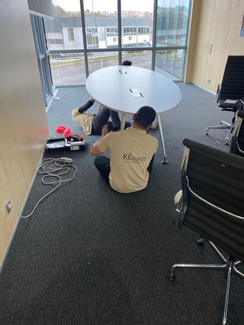 Dois homens consertando uma mesa