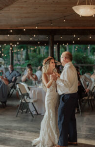 A bride dancing with her father at her wedding reception.