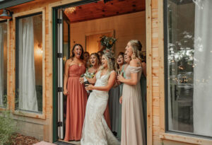 Bride and her bridesmaids popping the champagne and laughing.
