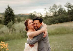 a bride and groom portrait with the couple hugging each other and smiling at the camera. Captured by Michelle Betz Photography