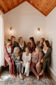 Bridal party photo of the girls and bride in their robes. They are smiling at each other.