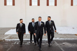 Bridal party group photo of the groom and groomsman. Everyone smiling and walking at Creekside Terrace. Captured by Michelle Betz Photography