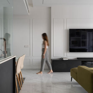 Woman walking through modern minimalist apartment