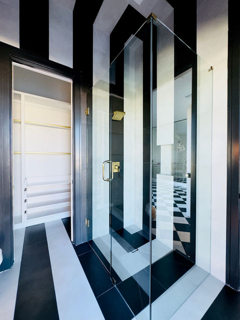 Modern bathroom with black and white striped walls, glass shower, and Fine Line Flooring