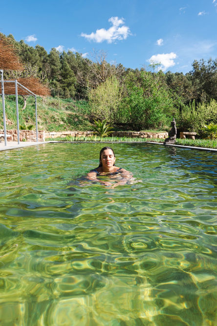 Baño en la piscina natural de aguas verdes rodeada de vegetación, Torres de Selma
