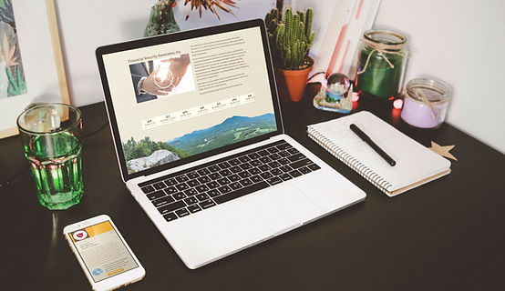 computer monitor showing a screen that has a laptop and homepage of a website