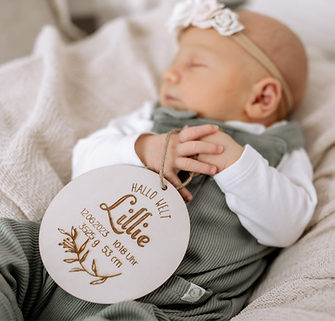 Babyfotograf bei Kassel fotografiert Neugeborenes Baby im Studio bei Kassel , Holzschild als Geschenk zur Geburt