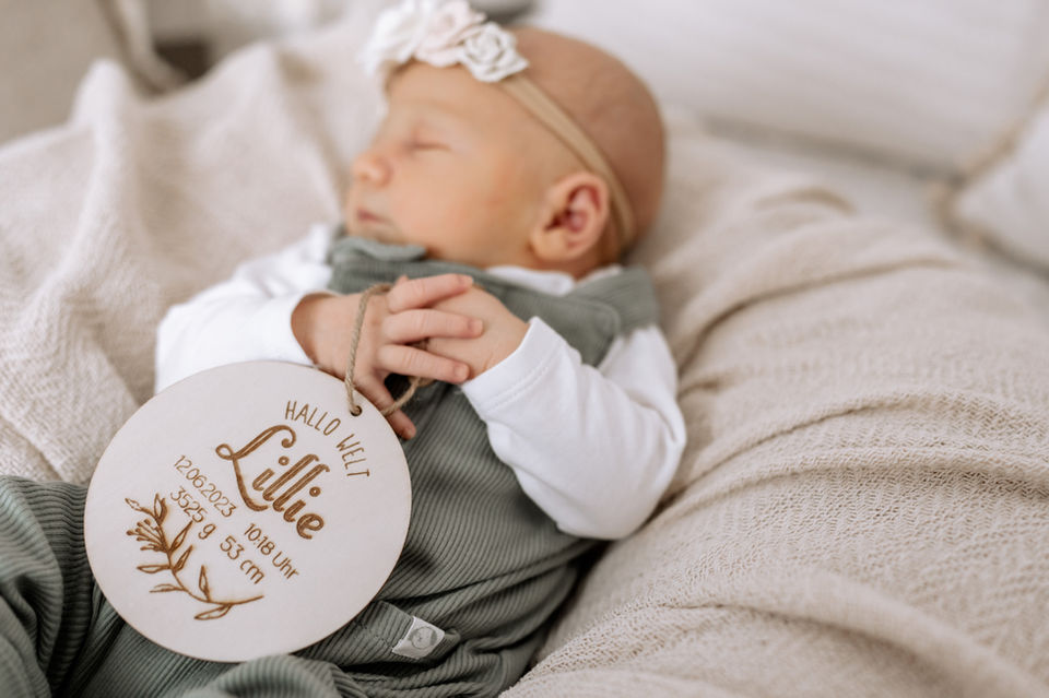 Babyfotograf bei Kassel fotografiert Neugeborenes Baby im Studio bei Kassel, Holzschild als Geschenk zur Geburt
