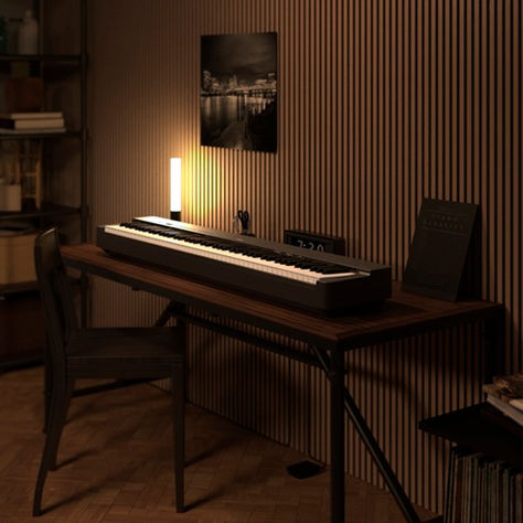 A black Yamaha P-223 in a brown lit room on a desk with chair