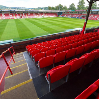 Cheltenham Town FC Main Stand featuring newly installed Link Mirage stadium seats overlooking the football pitch