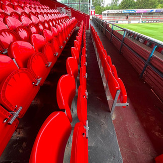 Close-up of Link Mirage plastic tip-up stadium seat installed at Cheltenham Town FC