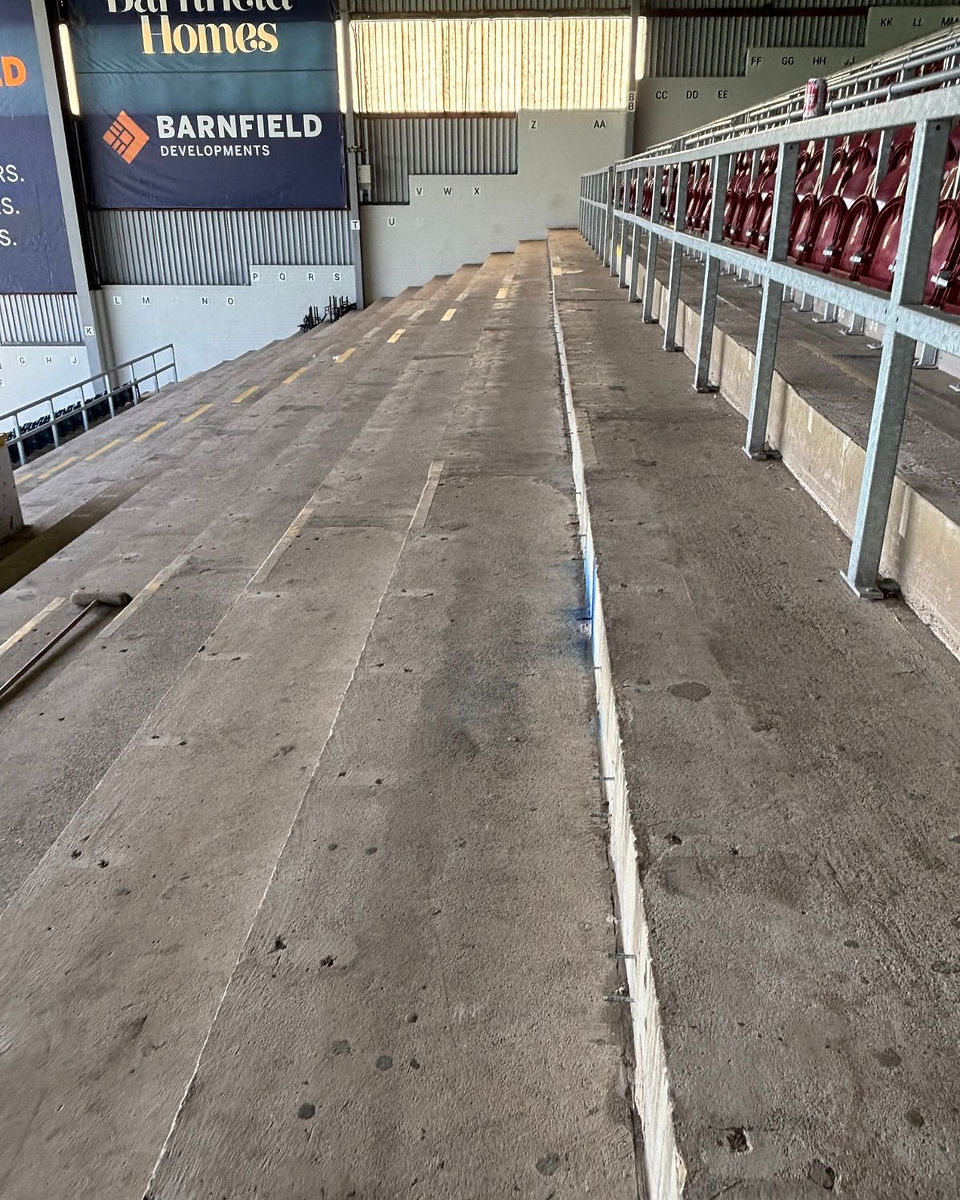 Side view of bare concrete stadium terrace pre-installation at Turf Moor