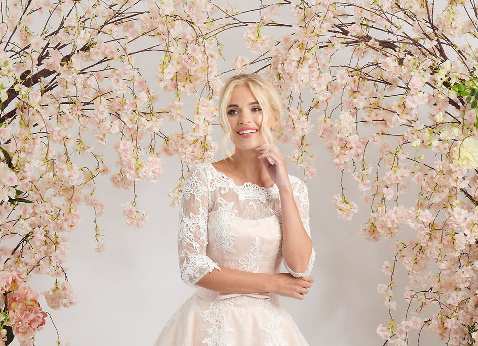 Thumbnail: Bride wearing Amelia by House of Mooshki, a blush ballerina-length wedding dress with ivory lace and three-quarter sleeves