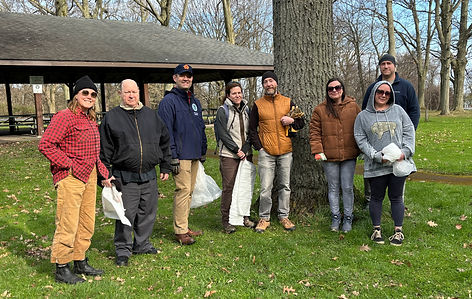A group of volunteers pick up trash at a park.