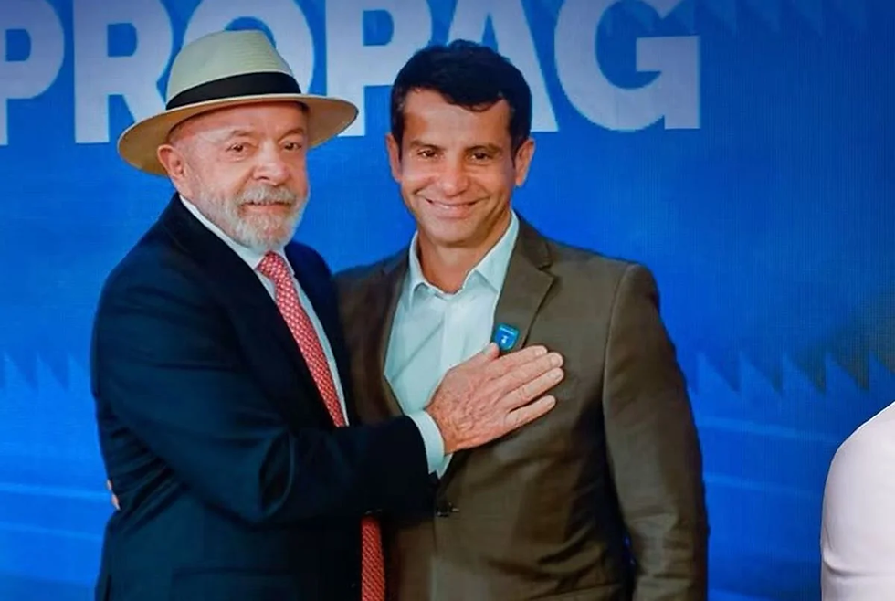 Luiz Inácio Lula da Silva (à esquerda, de chapéu panamá e terno) e Dr. Luizinho (à direita, de paletó cinza), deputado federal e líder do PP na Câmara dos Deputados. | Imagem divulgação.