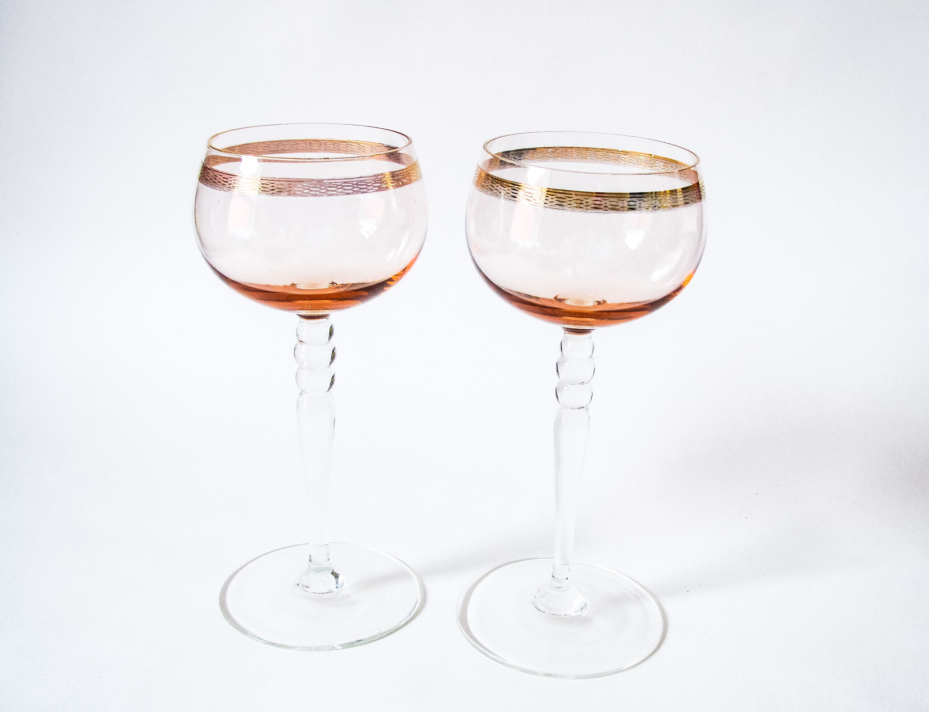 set of 2 blush hock wine glasses with gold band and clear stem with 2 knops.