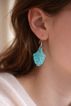 Une boucles d'oreille en resine verte porté