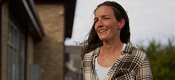Woman smiling outside recovery center, reflecting on her journey in recovery_edited.jpg