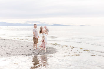 Meliza Orellana Photography_Family Page Gallery_Vancouver Photography_Family_ Man and woman holding the baby in front of the sea.