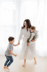 Meliza Orellana Photography_Family Page Gallery_Vancouver Photography_Family_ Mother with the baby in her lap and holding hands with another child.