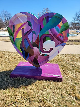 A standing heart painted purple with leaves that says KC on the front.