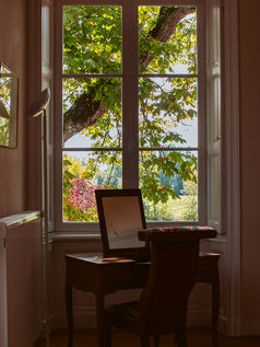 Vanity desk with mirror in the master dressing room overlooking bright gardens.