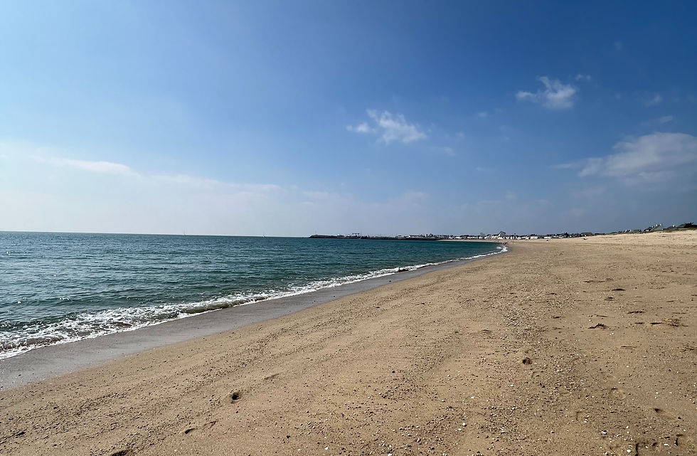 Eye-level view of a quiet beach in Pornic with calm waves and soft sunlight