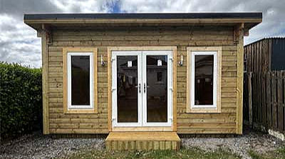Eye-level view of a modern garden room with large windows and wooden exterior