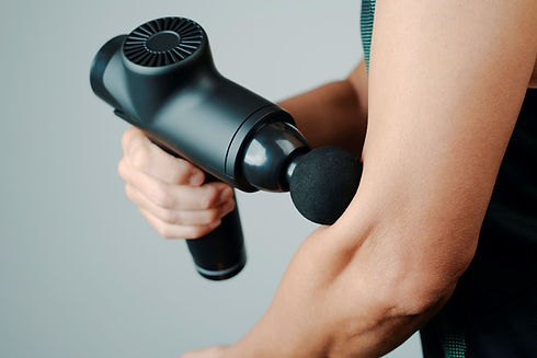Man+using+a+massage+gun+on+his+arm.jpg