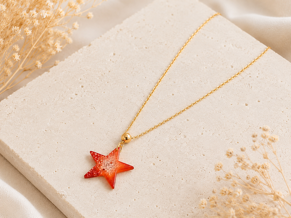Collier étoile orange en résine pailletée sur chaîne dorée