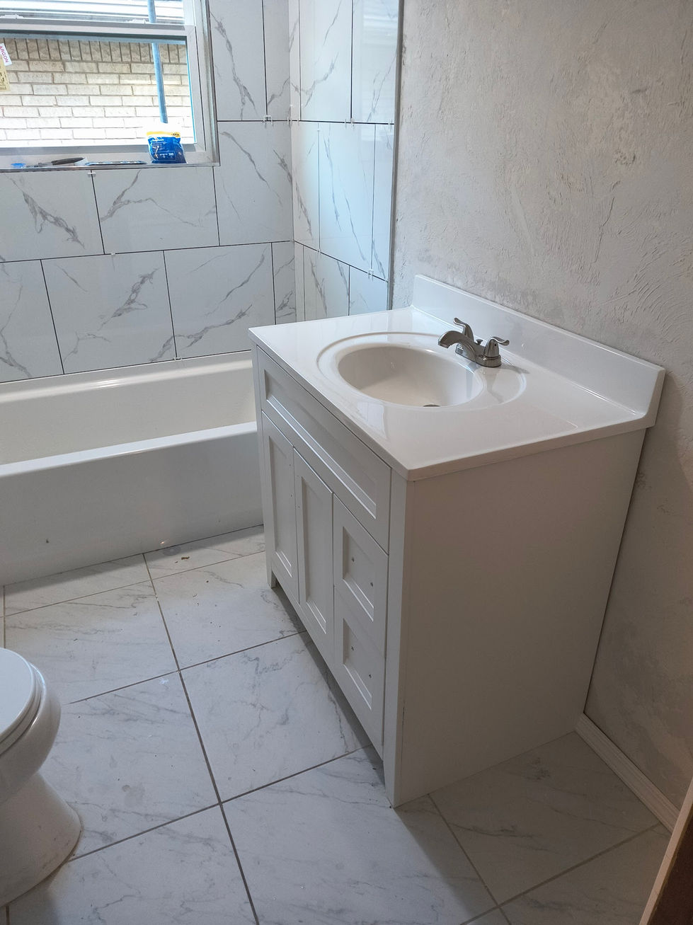 Updated vanity next to new tile wall.