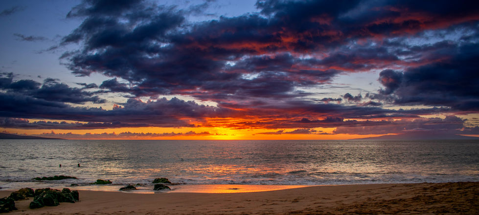 a sunset over the ocean with a cloudy sky