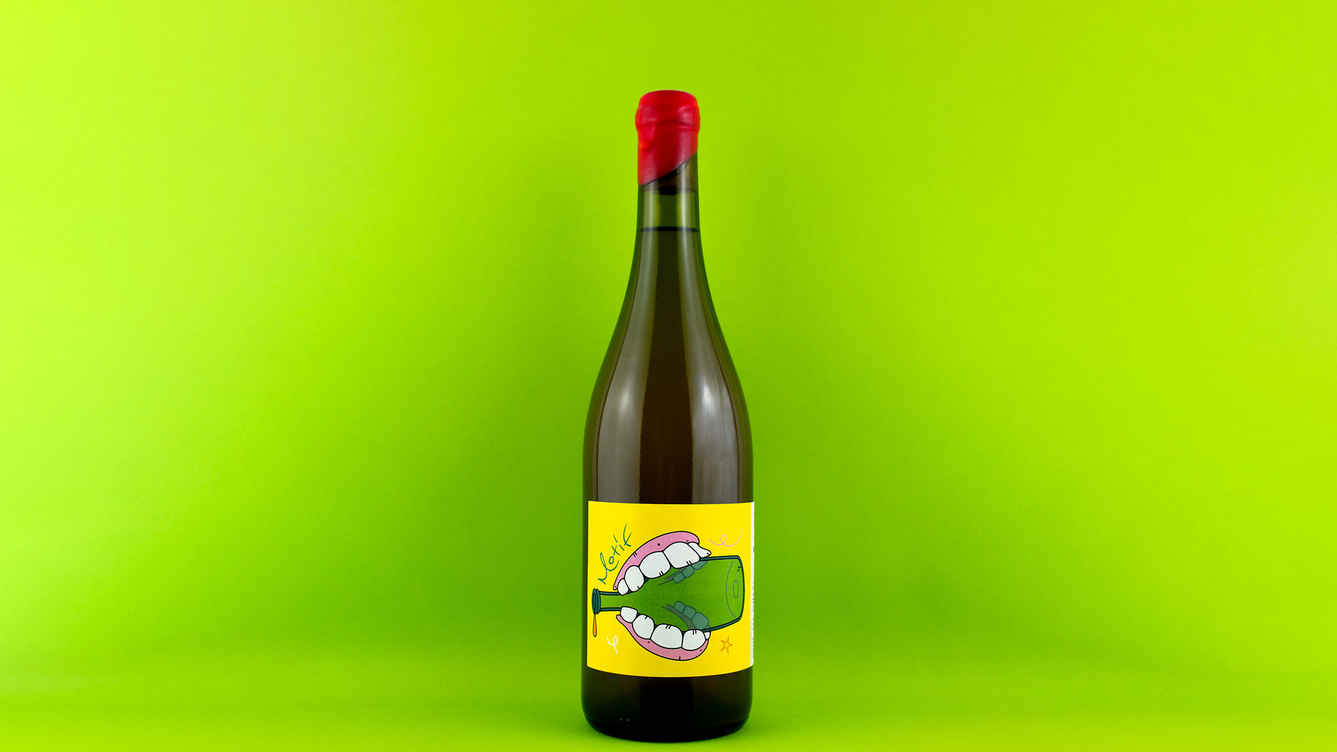 A wine bottle on a light green background. On the bottle, there’s a label illustrated for Motif wine shop by artist Mikko Heino. The illustration shows dentures biting an empty wine bottle.