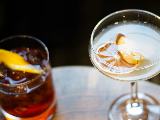 two drinks with a food menu on a table.