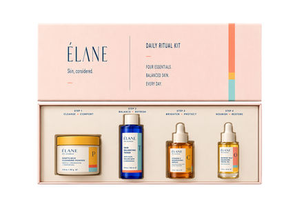 Open ÉLANE Daily Ritual Kit containing Goat’s Milk Cleansing Powder, Skin Balancing Toner, Vitamin C Nourishing Serum, and Nutrient-Rich Balancing Facial Oil arranged in four labeled steps.