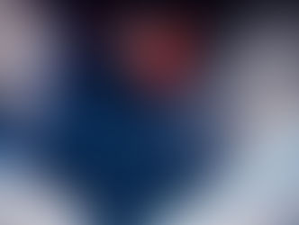 A Japanese snowboarder in a red and white uniform soaring high