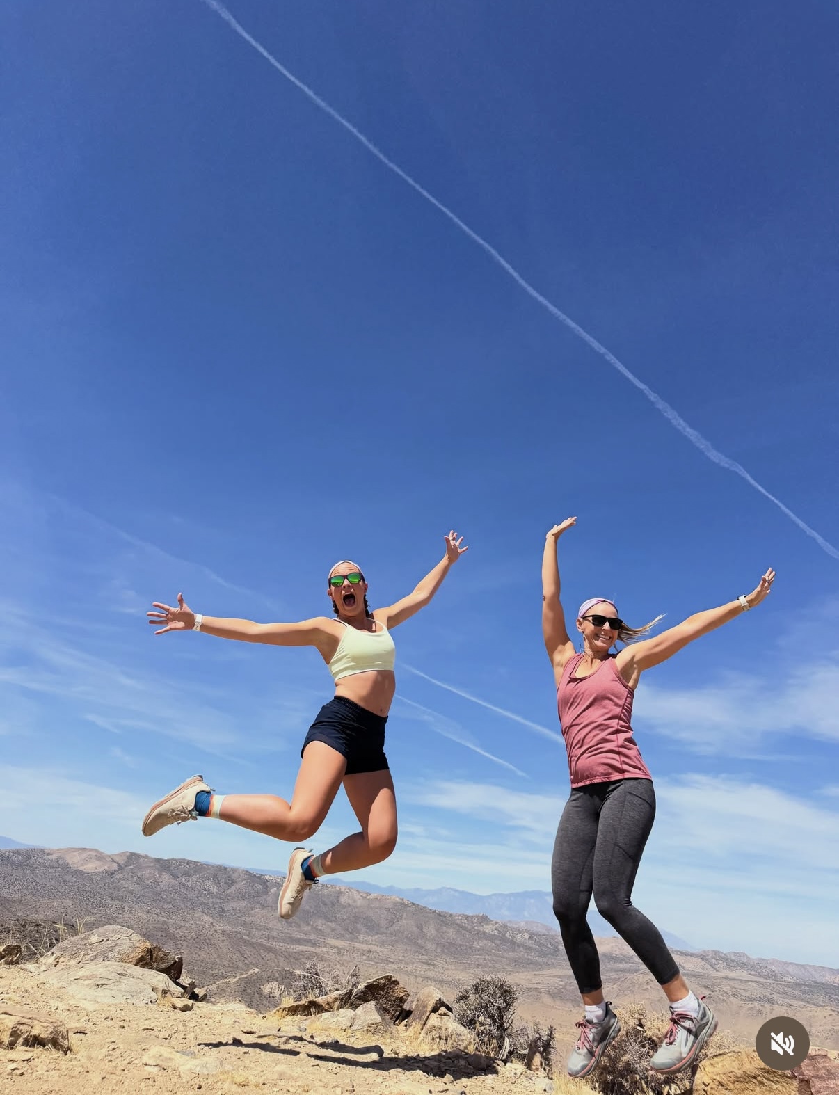 Two hikers jumping on a high desert trail