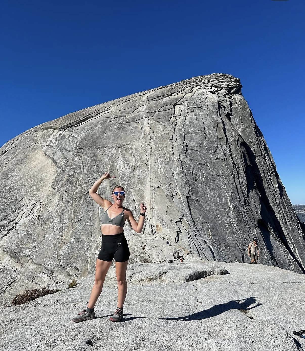 Erin on a mountain trail beneath Half Dome