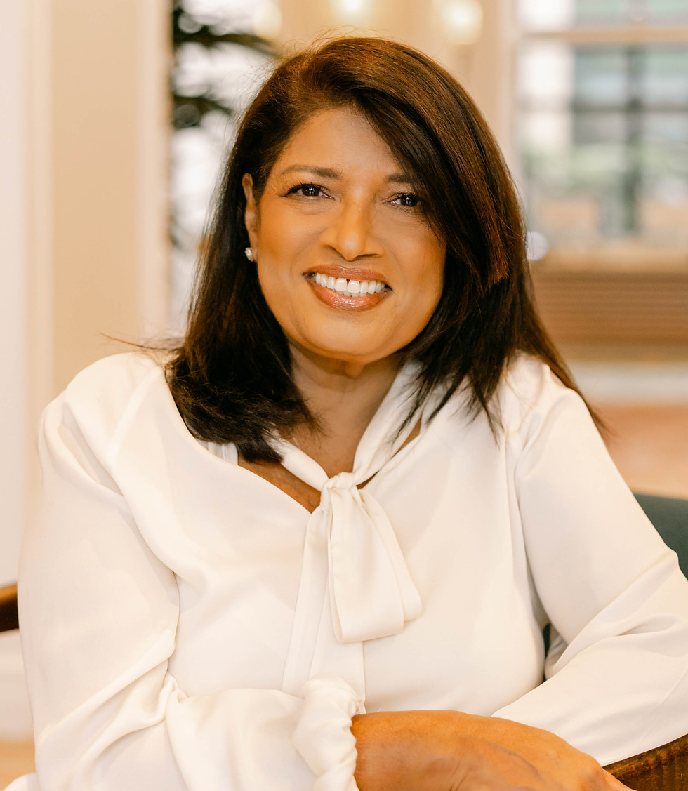 Indoor sitting on chair with all white smiling- hands on arm of chair.jpg