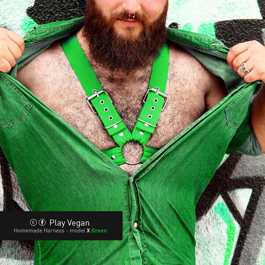 man with open shirt and green harness