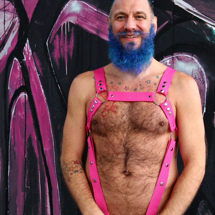 man with full body pink harness