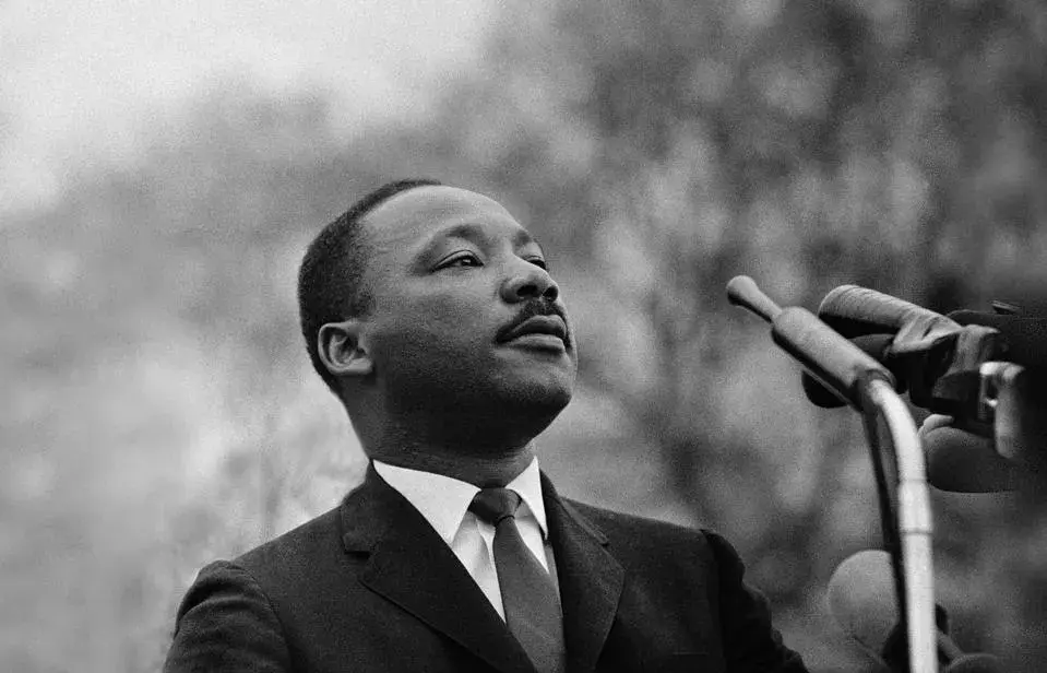 Black and white image of Martin Luther King, Jr at a microphone.