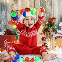 baby playing with holiday lights
