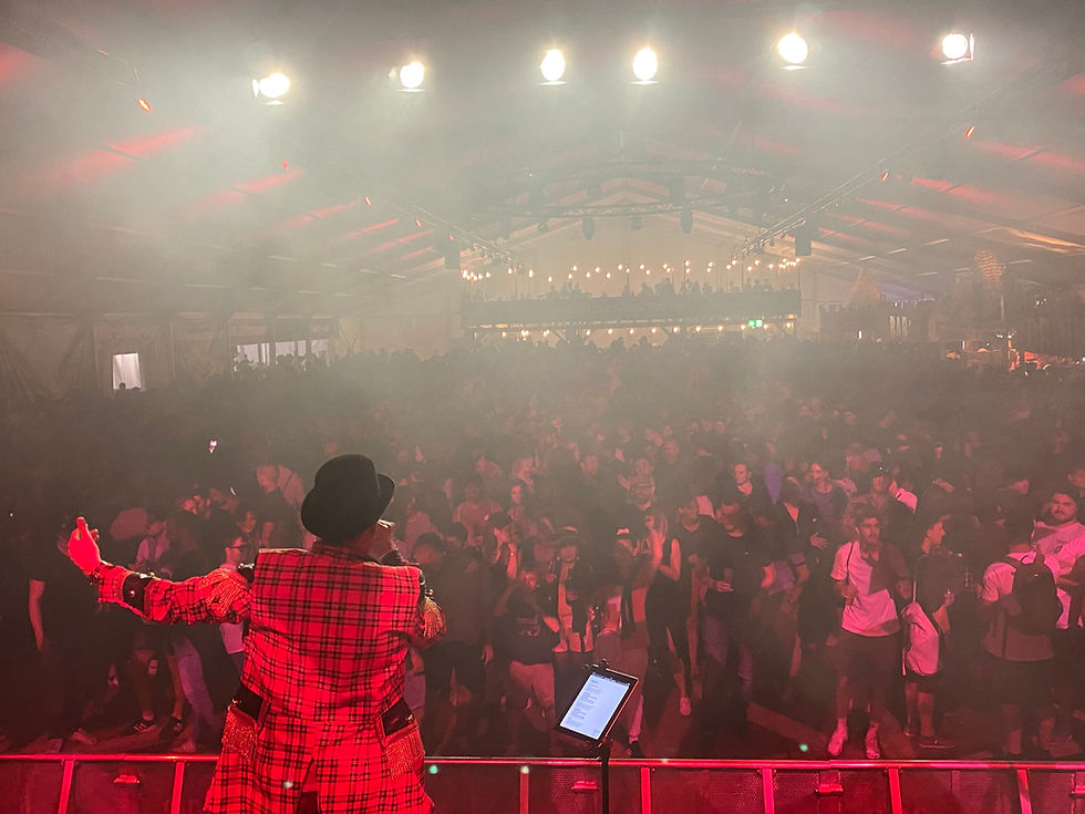 Weitwinkelaufnahme eines großen Festzeltes mit einer live spielenden Band auf der Bühne