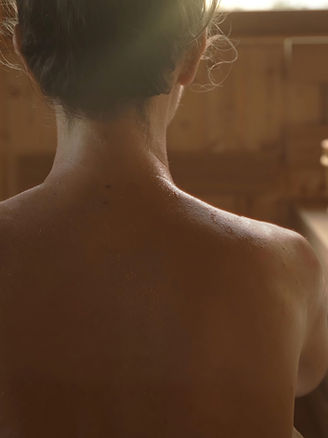 Woman relaxing and sweating in hot sauna. Real, authentic sauna moment..jpg