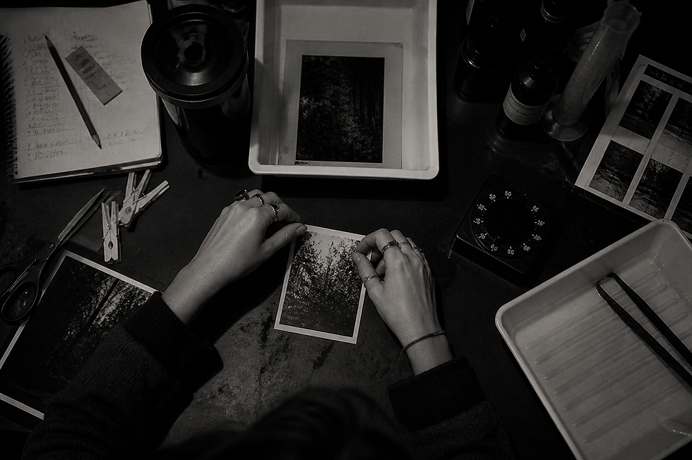 Hands holding printed photograph over minimal workspace