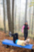 Christine standing next to a woman doing a workout in the woods