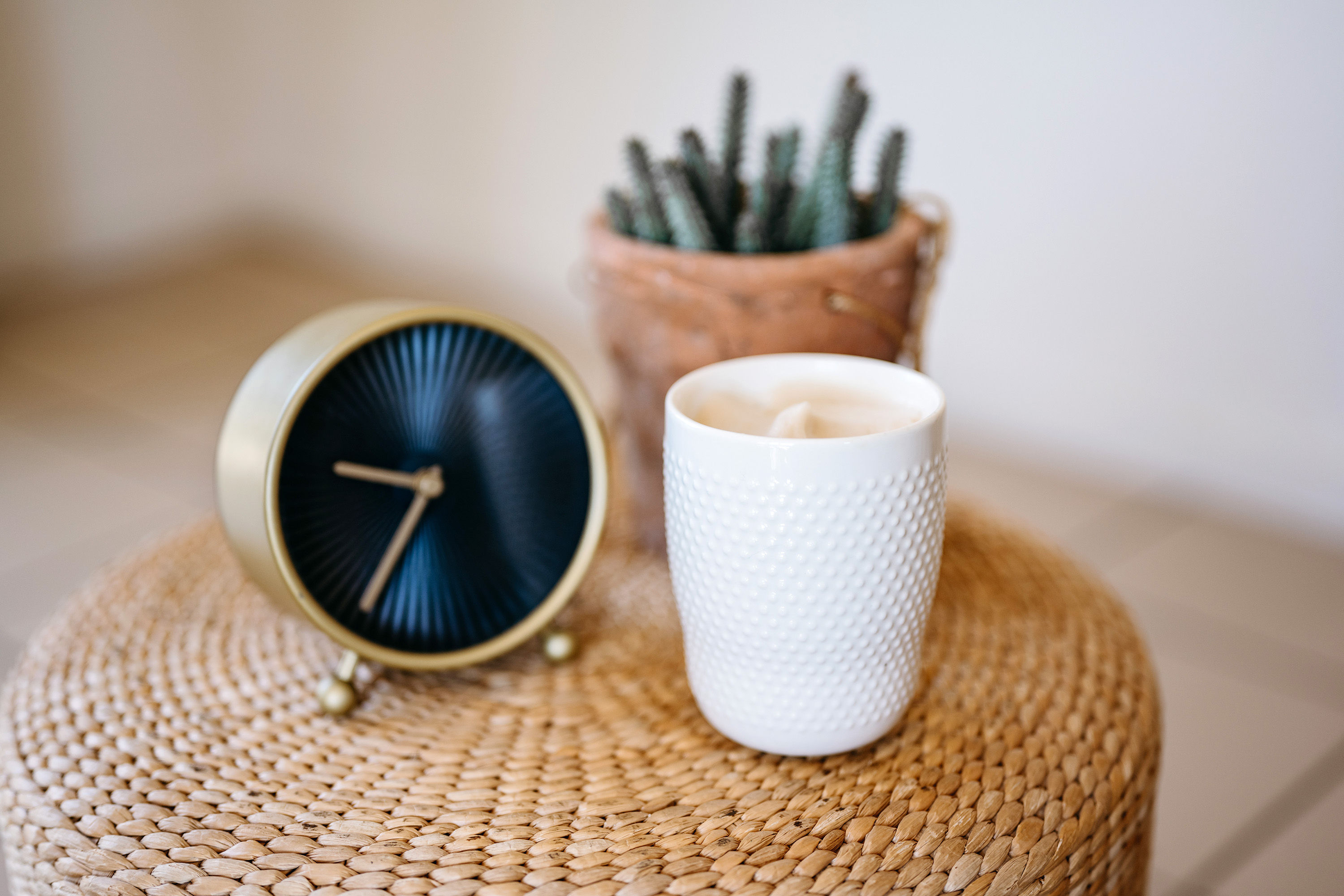 Woman sitting in her office with a smile on her face, looking at her computer screen with cup of coffee in hand